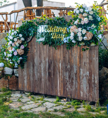 Rustic wedding photo zone. Handmade wooden decorations with flowers. Wedding day