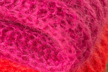 Wool mohair clothes texture closeup. Close-up of red and cherry colored mohair folded sweaters. Cashmere Soft and fluffy wool macro shot. Woolen fabric. Knitted hairy detail texture surface