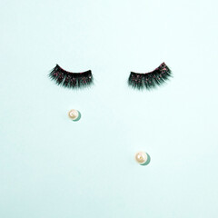 Minimalistic concept, woman's eyes and tears on a pastel background.