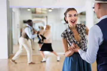 Verduisterende gordijnen Dansschool Cheerful female practicing lindy hop in pair with man