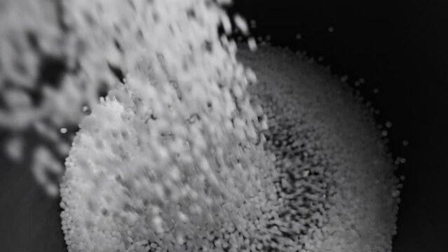 Filling the tank with plastic granules. The process of producing parts from polyethylene compound. White granules are poured into a container.