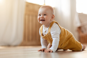 Cute little baby boy discovering world, crawling by home - obrazy, fototapety, plakaty