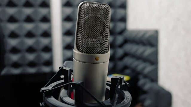 Recording studio, microphone close-up. Podcast recording, radio, dubbing, audio track. A small room with musical equipment, a computer monitor