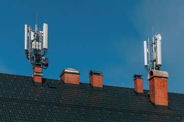 Mobile telephony base station and signal repeater antenna on building roof, telecommunication...