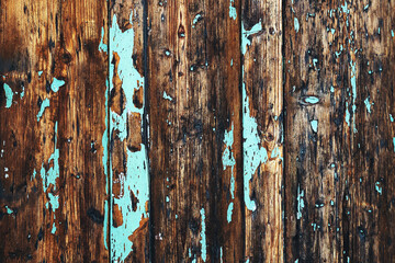 Old wooden surface with blue paint peeling off the surface