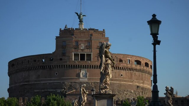 Cinematic view of Castel SantAngelo is Roman architectural monument also known as Hadrian Mausoleum, sometimes called Sad Castle, on sunny day with blue sky on background. Shooting in slow motion.