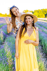 Two women pose in a blooming lavender field