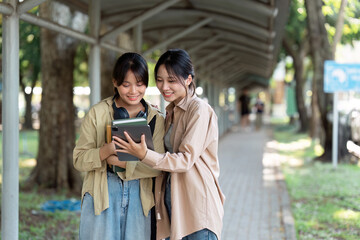 Fototapeta premium university students using a digital tablet while walking to next class