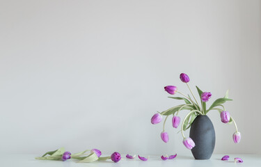  purple tulips on white shelf on background wall