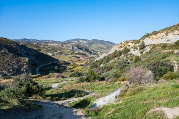 Fototapeta na wymiar Rocky mountains and green hills over blue sky, Cyprus