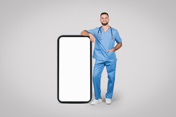 Young male doc with huge phone, ad backdrop