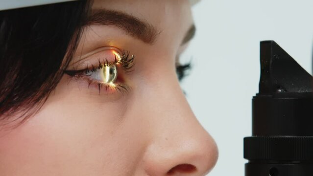 Close-up of a young woman having her vision tested on an ophthalmology diagnostic vision testing equipment. Professional ophthalmological apparatus.