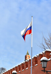Flag of Russian Federation against background of Kremlin wall in winter. Moscow, Russia