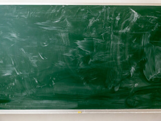 Closeup of a green school chalkboard with abstract white chalk pattern.