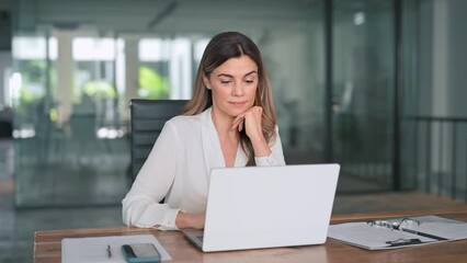 Smiling busy mature middle aged professional latin business woman manager executive looking at laptop computer technology in office working on digital project sitting at desk. - Powered by Adobe