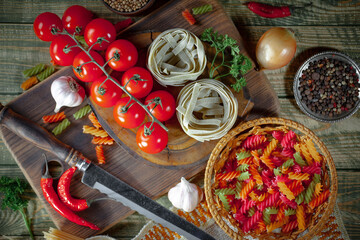 Raw pasta in composition with vegetables in the kitchen.