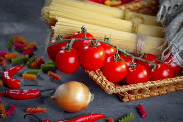 Raw pasta in composition with kitchen accessories in the kitchen on the table.