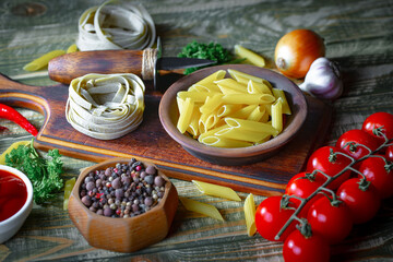 Raw pasta, spaghetti in a plate with seasonings and vegetables. Raw, ready-to-cook dish.