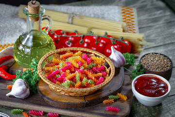 Raw pasta, spaghetti in a plate with seasonings and vegetables. Raw, ready-to-cook dish.