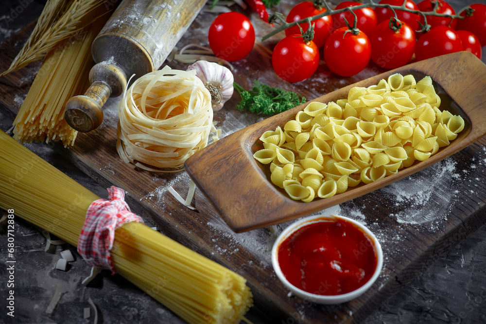 Wall mural Raw pasta in composition with kitchen accessories in the kitchen on the table.