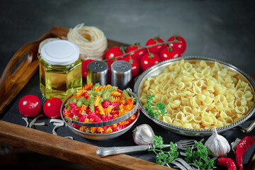 Raw pasta in composition with vegetables in the kitchen.