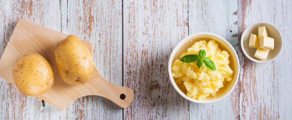 Bowl with delicious homemade mashed potatoes and basil on the table top view web banner
