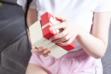 young woman holding gift box on the background of her hands.