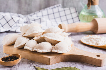 Homemade raw dumplings with meat on a cutting board on the table