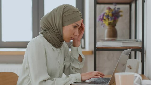 Working burnout. Upset middle eastern woman manager creating development plan on laptop and feeling stuck