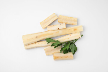 Cut raw salsify roots and parsley on white background, flat lay