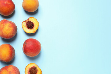 Delicious juicy peaches on light blue background, flat lay. Space for text