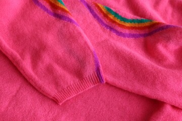 Beautiful pink sweater as background, closeup view