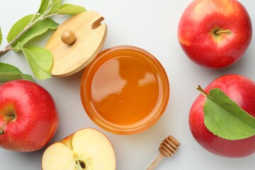 Sweet honey and fresh apples on white table, flat lay