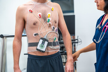 Cardiologist attaching a Ecg Holter to a patient to perform a cardiovascular stress test in the...