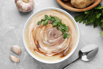 Delicious cream soup with soy sauce and parsley served on light grey marble table, flat lay