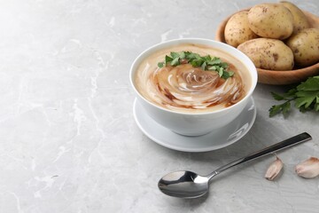 Delicious cream soup with soy sauce and parsley served on grey marble table. Space for text