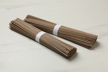 Uncooked buckwheat noodles (soba) on white marble table