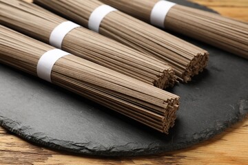 Uncooked buckwheat noodles (soba) on wooden table, closeup