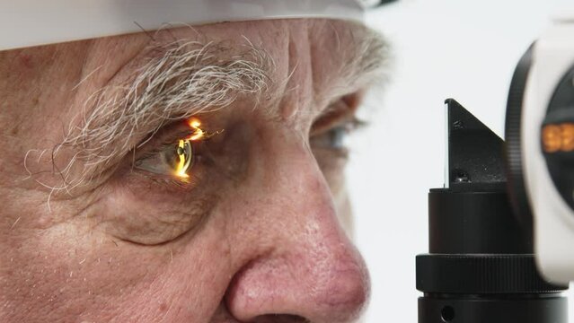 An elderly patient at an ophthalmologist's appointment. An ophthalmologist examines a client using a slit lamp in the office. Doctor doing an eye test using professional diagnostic equipment