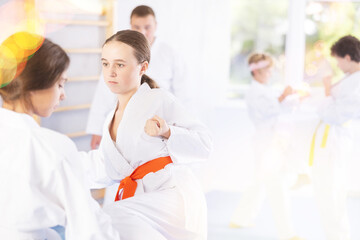 Fototapeta na wymiar Child boys and girls partners during martial arts karate class train to perform basic blows to opponent with hands and feet. Preparation of athletes for competitions