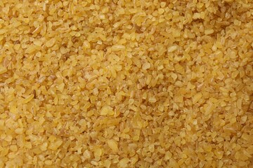 Pile of raw bulgur as background, top view