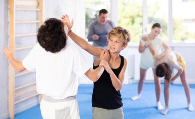 Fototapeta premium Two preteen boys doing a head kick during self-defense training