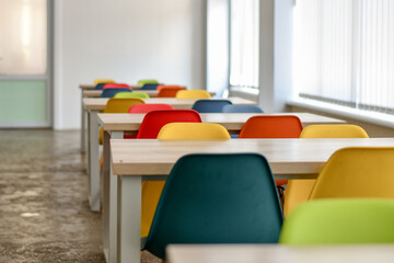 Colorful chairs in the empty school dining room. Selective focus.