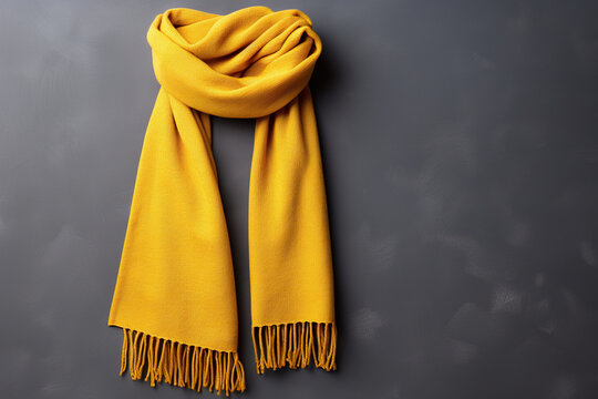 Yellow warm scarf on a background of a gray concrete wall. Generated by artificial intelligence