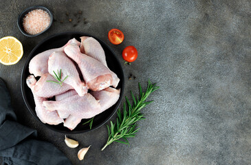 Raw chicken legs or drumsticks with rosemary, spices and vegetables. Top view. Copy space