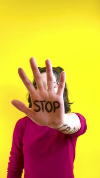 Video of close-up of a woman's hand with the word stop written on it. Concept of struggle and equality of women's rights. Women's day.