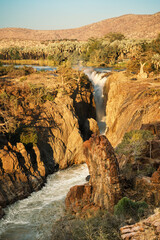 Epupa Falls, Kunene Region, Namibia, in warn sunset light. Epupa Falls is a series of large...