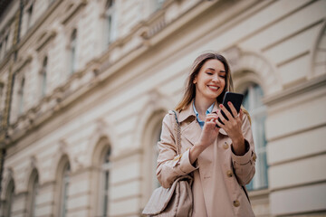 Smiling woman using mobile phone while outside on a city street