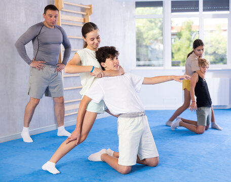 Pupils train to perform defense of strangling opponent, while learning self-defense techniques. Child practices strangulation technique expedient during classes with teacher in krav maga class