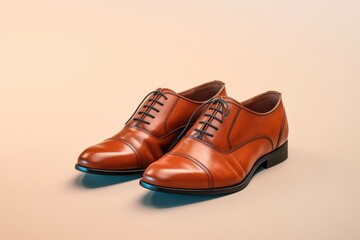 A pair of stylish light brown men's leather shoes on a solid neutral background